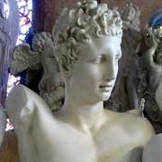 Classical Greek-style male bust with curly hair and detailed facial features, displayed on a round pedestal base. Side View