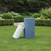 Fluted cylindrical containers with vertical grooves, inspired by classical Greek architectural columns, minimalist and sculptural design. Side Angle