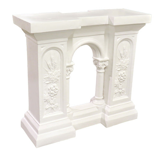 Classical console table with ornate floral reliefs, arched center opening, and column details in old world European style