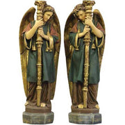 Pair of ornate Baroque-style angel statues with detailed wings, classical robes, and tall candlesticks in a reverent pose.