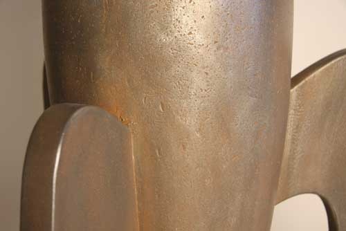 Rocket sculpture with smooth, streamlined form and three curved legs, featuring a minimalist, old world European retro-futuristic style. Side Angle
