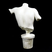Classical Greek male torso sculpture with missing head and arms, displayed on an ornate fluted pedestal in old world European style. Side View