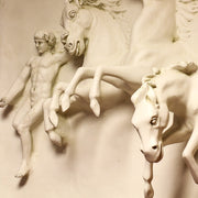 Classical bas-relief sculpture featuring a male figure and three dynamic horses in an ornate, old world European style. Different Angle