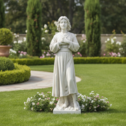 Classical Renaissance-style statue of a serene young figure in flowing robes, hands crossed over chest, standing on a decorative base. Side Angle