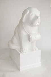 St. Bernard dog statue with barrel collar, seated on a pedestal in classical European style with subtle ornate detailing. Side View